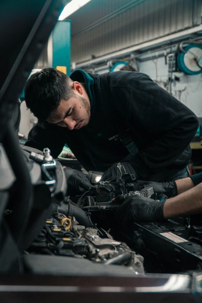 Automotive mechanic working on a vehicle in a professional repair workshop
