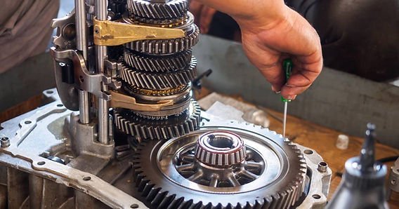 Disassembled automotive gearbox parts arranged neatly on a clean metal workbench.