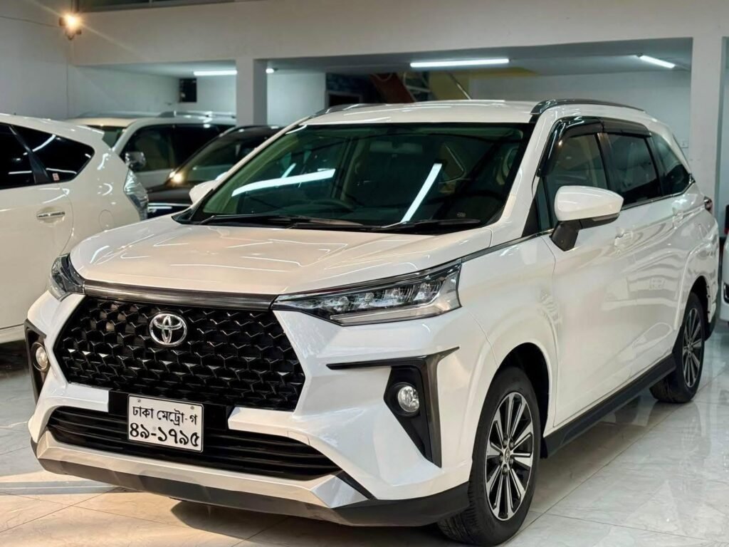 A hybrid car being inspected inside a clean auto workshop in Dhaka.